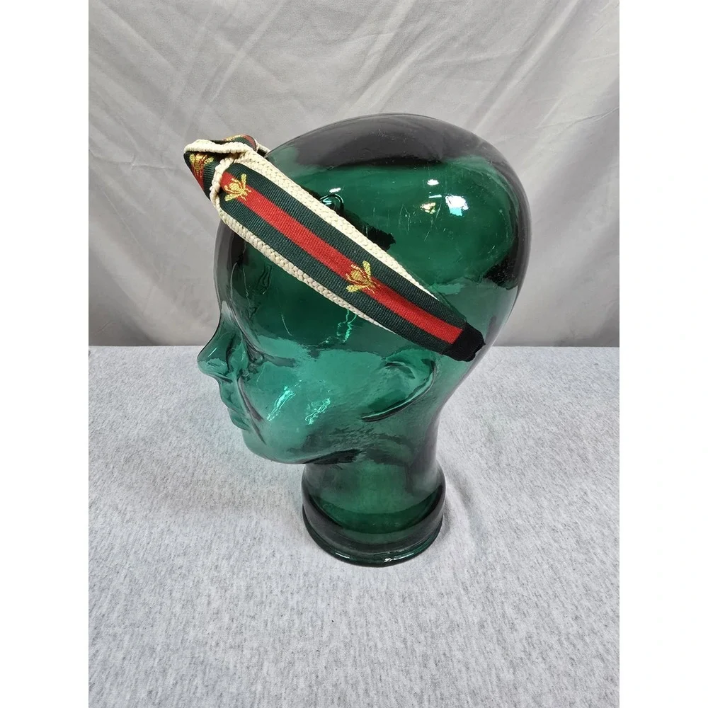 Bee Headband woven straw top-knot headband featuring a red and green striped...